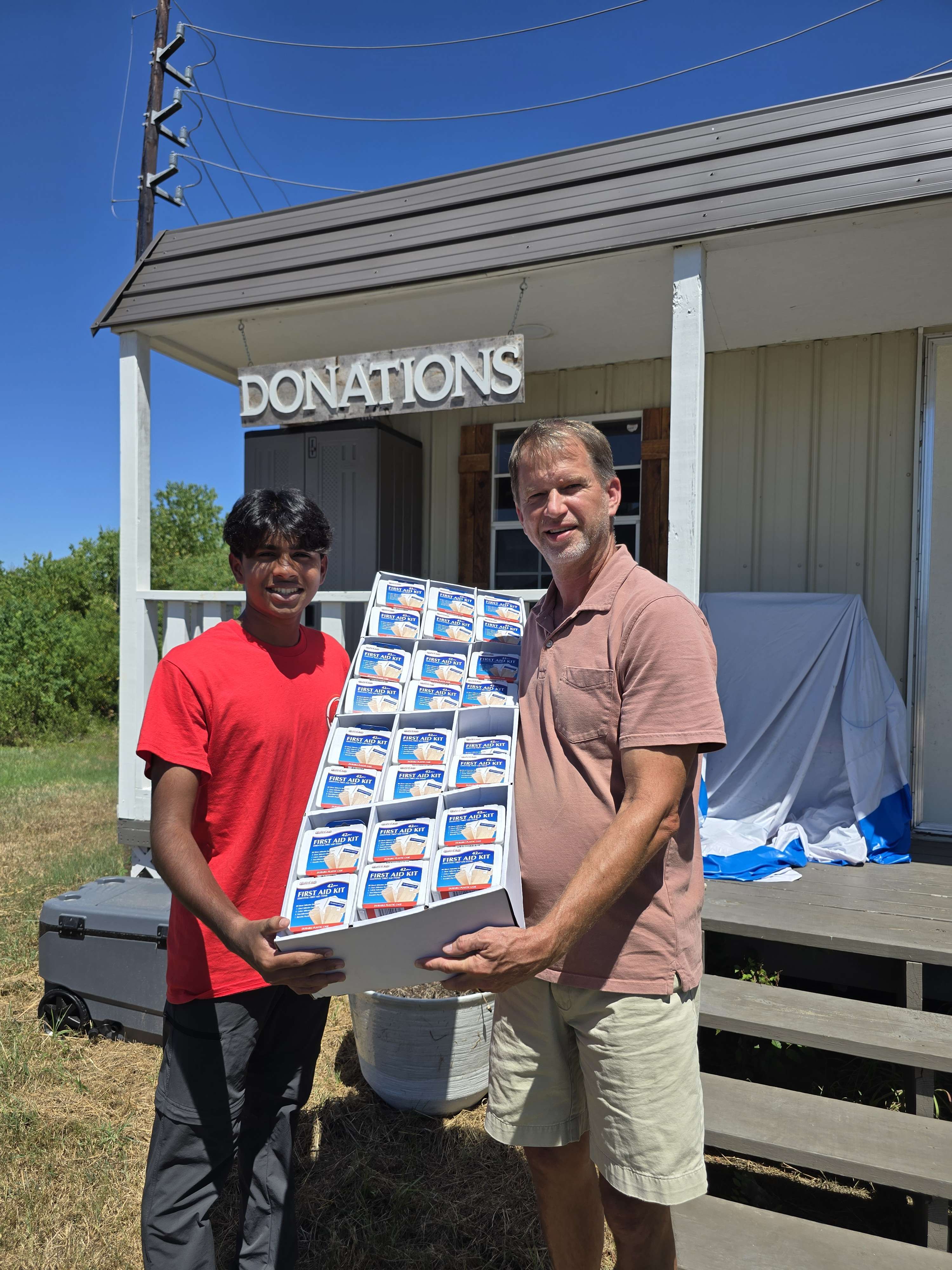 AccessAid volunteers handing off first-aid kits at Abba's House