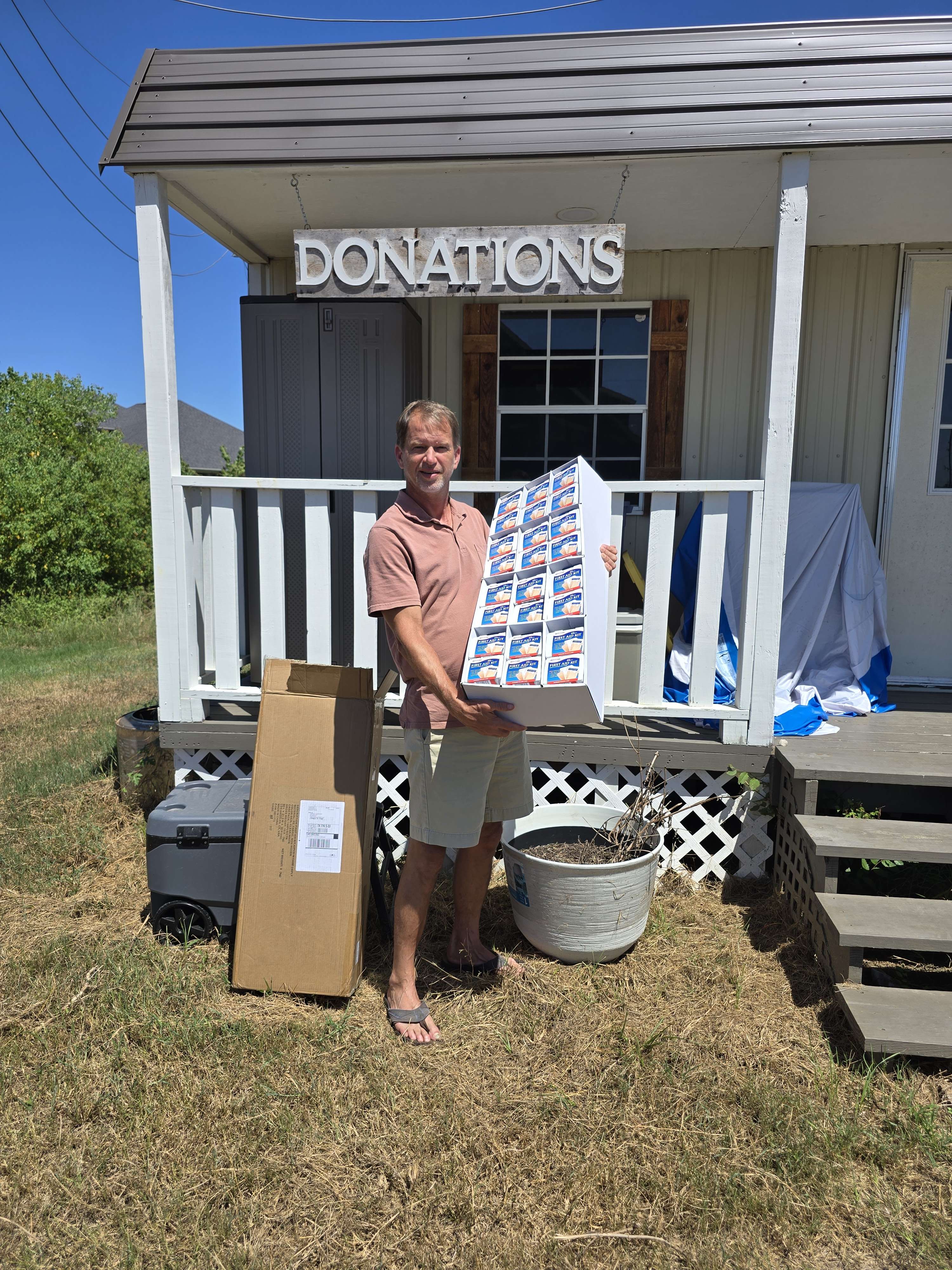 Abba's House staff member holding a box of first-aid kits