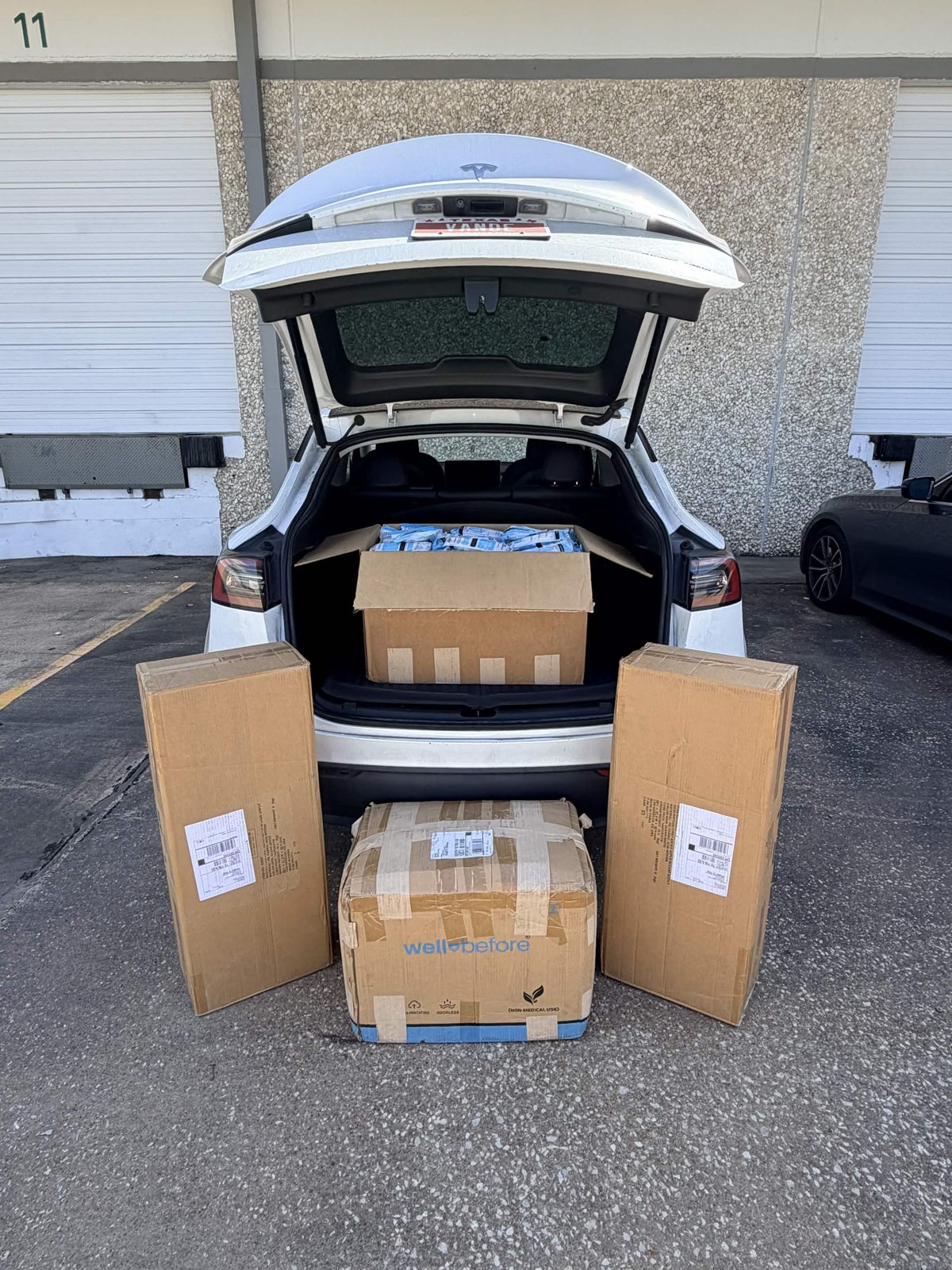 Boxes of first-aid kits and KN95 masks stacked at the trunk